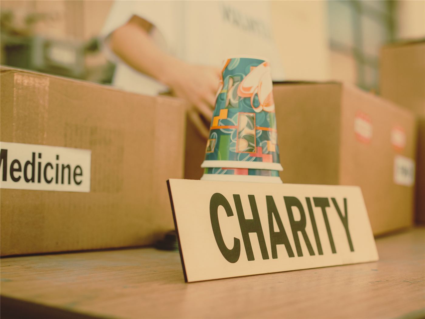 Boxes of donated medicine beside a charity sign at an aid drive